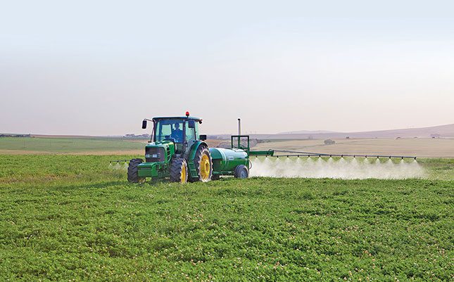 tractor spraying farm field